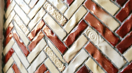Mosaikbelag im Fischgrät-Verlegemuster an einer Wand